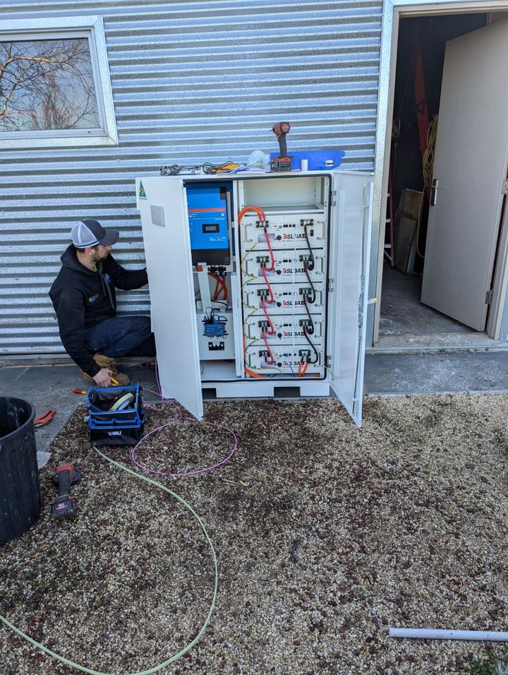 Technician wiring a battery cabinet during installation