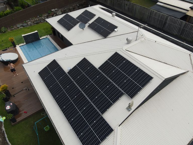 Aerial view of rooftop solar arrays across a coastal town