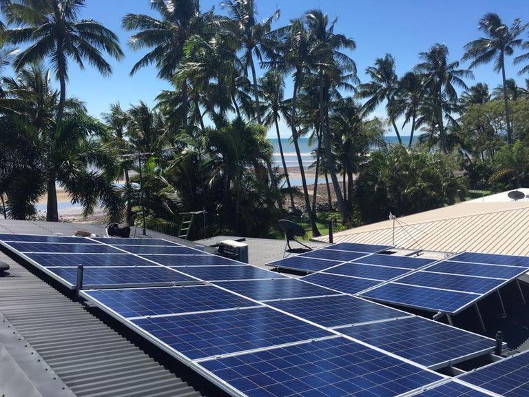 6.89kW rooftop solar array above palms near the beach, Mackay QLD