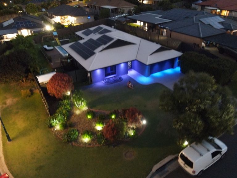 Night drone photo of a solar home with landscape lighting
